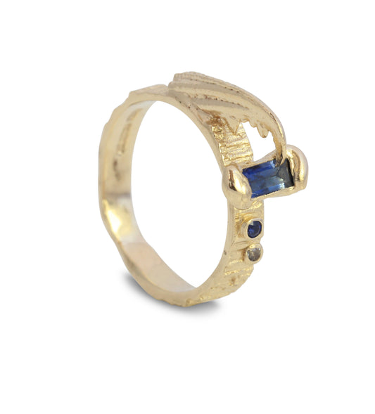 Gold textured crab claw ring with sapphires on a white background