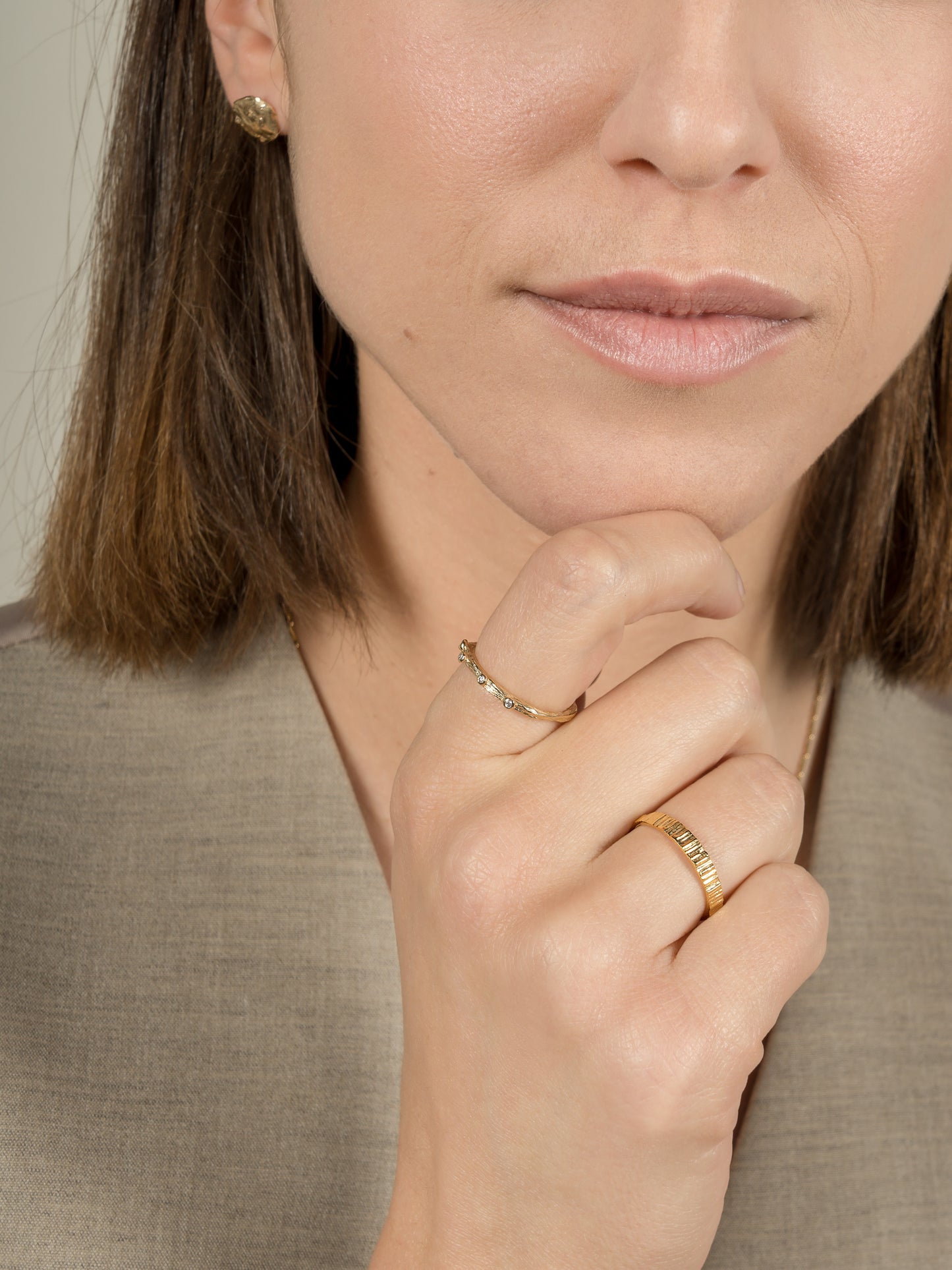 Model wearing two gold wedding rings.