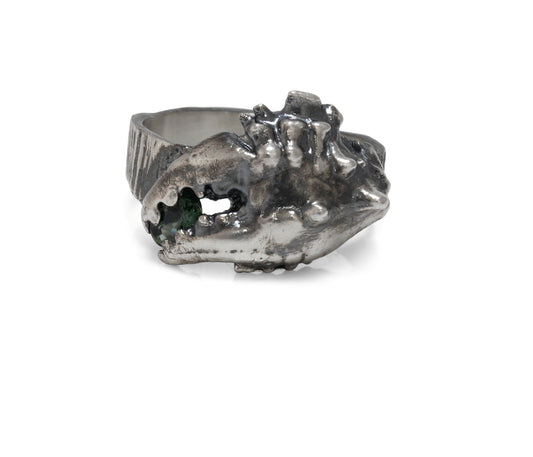 Straight view of a blackened silver ring shaped like a crab claw holding a green sapphire gemstone. Perfect for a mans Christmas present.