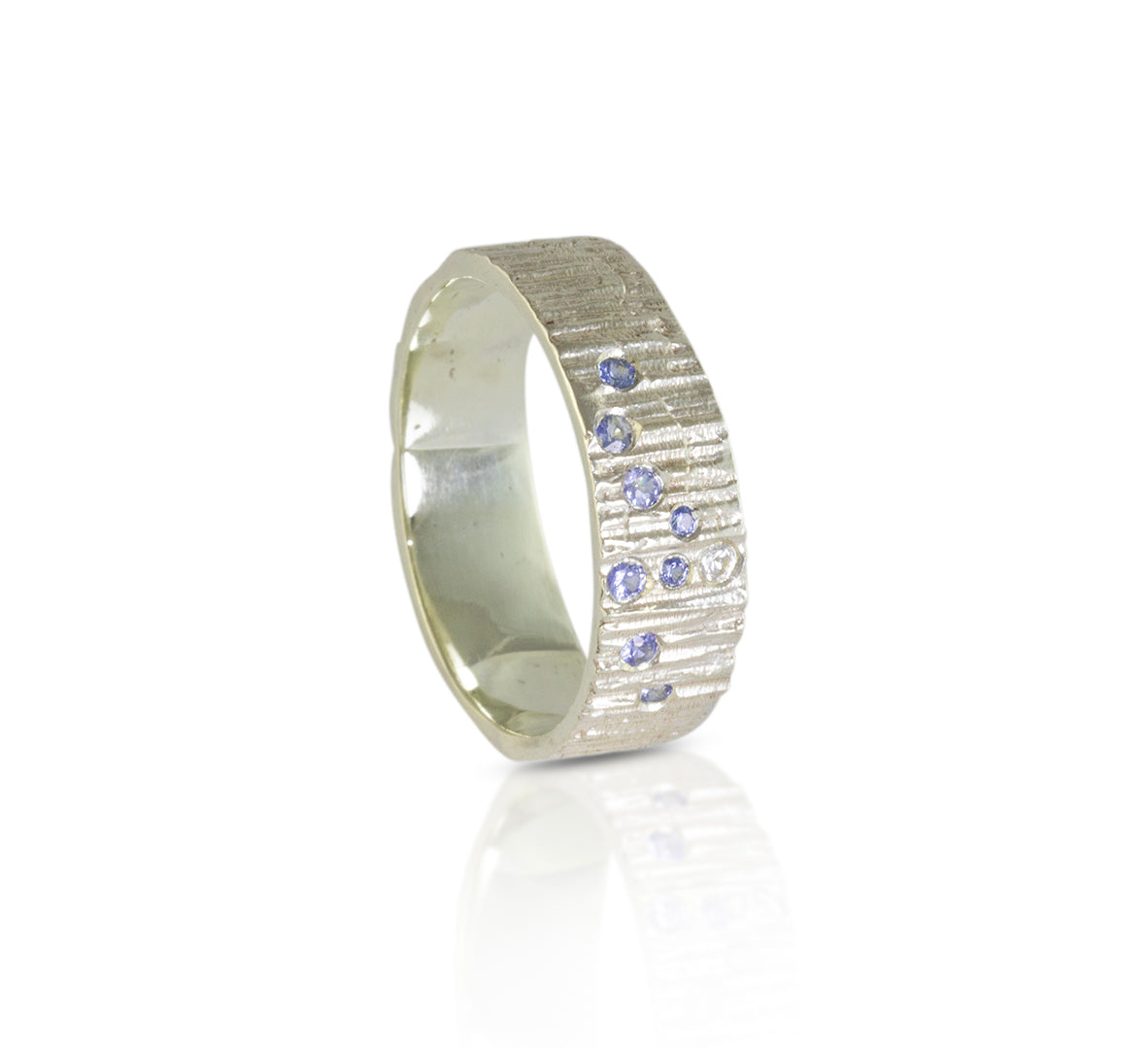 White gold ring in a thick 6mm band with 9 sapphires set in the style of a wave