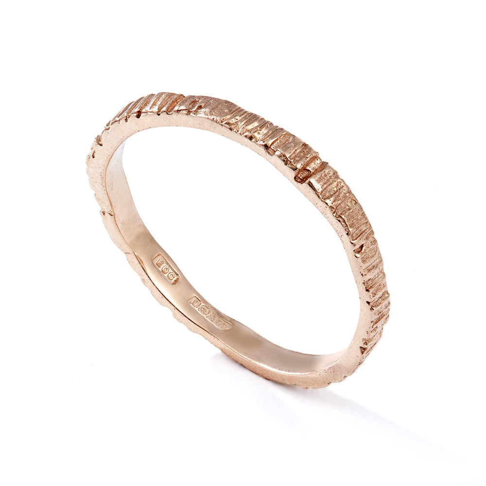 Picture of a rose gold, dainty alternative wedding band that has been cast from bark so it has organic grooves and textures. Handmade by Irish jeweller Eily O Connell who lives in Bristol. ll