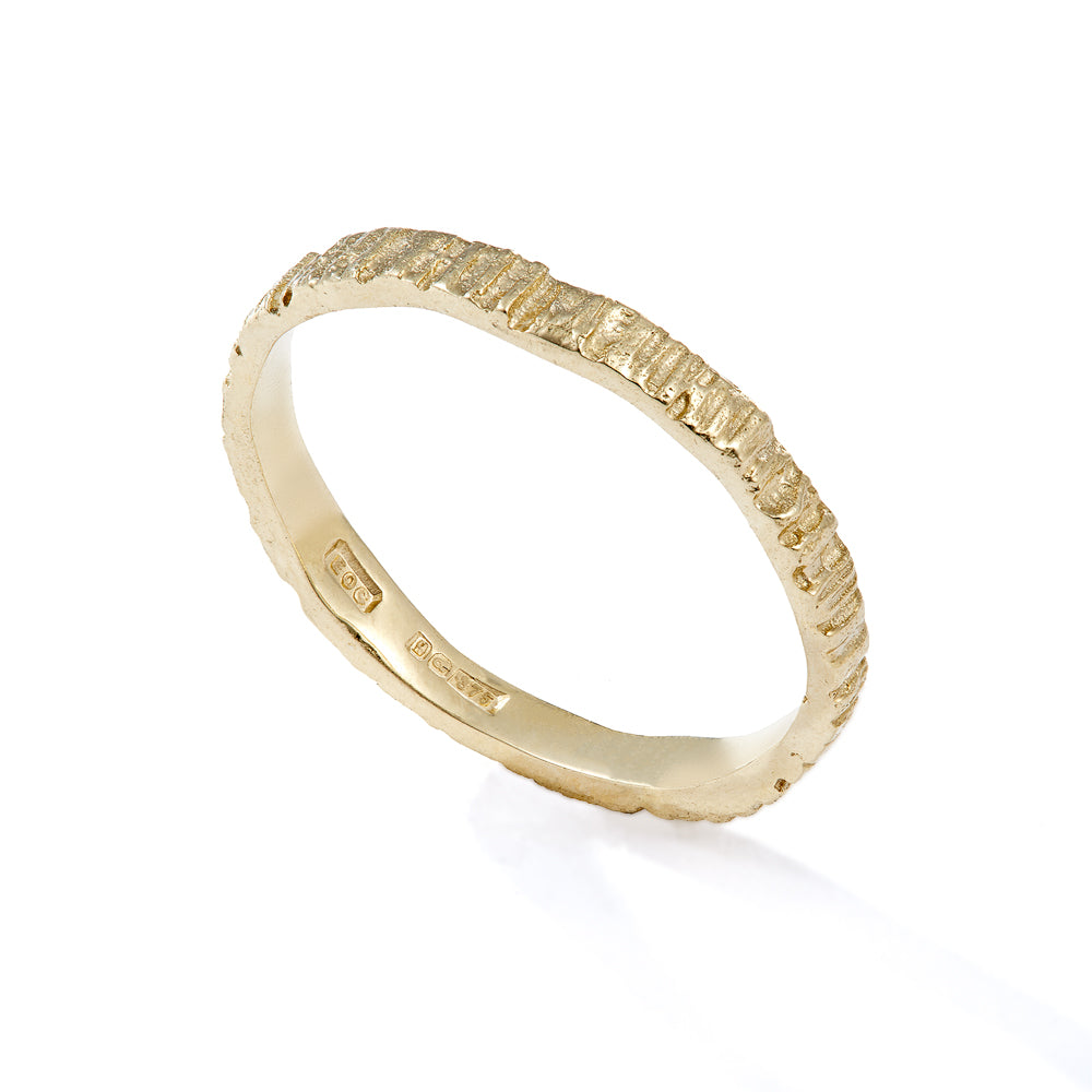 Picture of a gold alternative wedding band that has been cast from bark so it has organic grooves and textures. Handmade by Irish jeweller Eily O Connell who lives in Bristol.