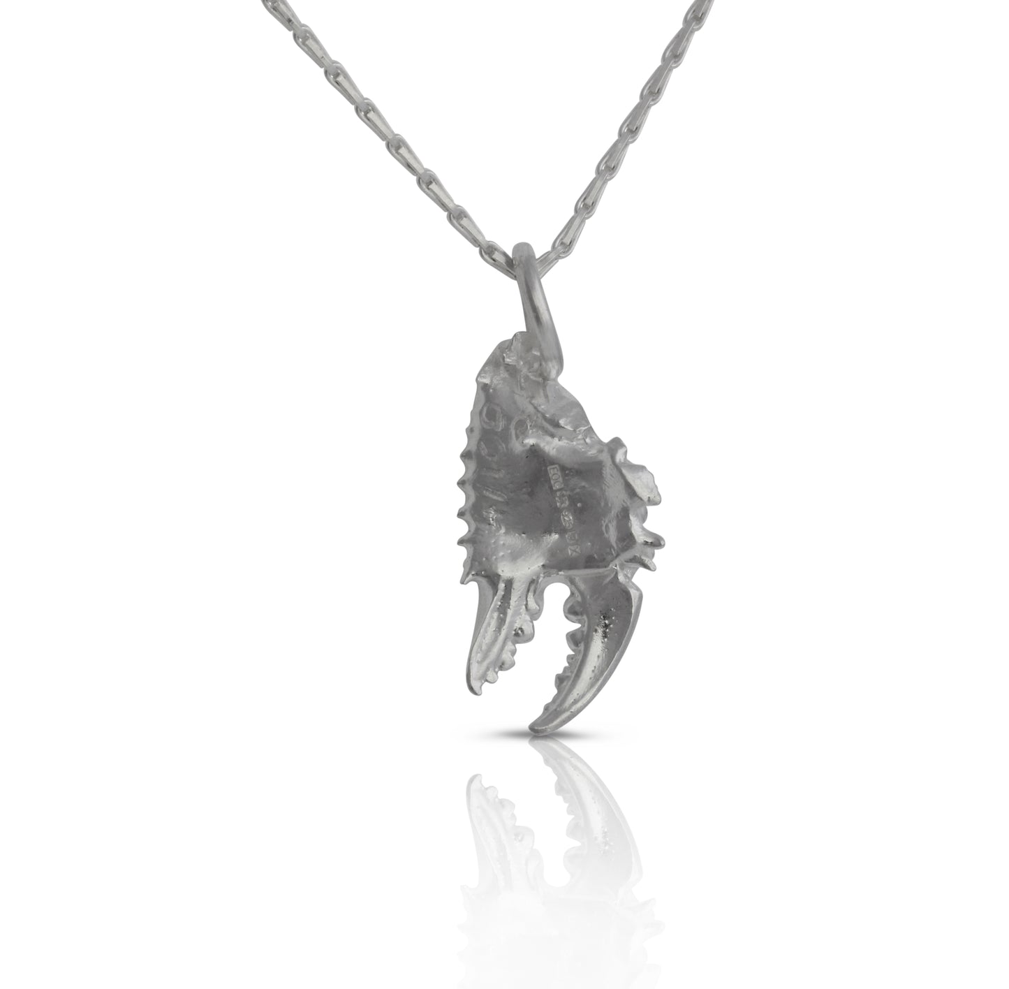 Handmade silver pendant cast from crab claw showing the hallmark.
