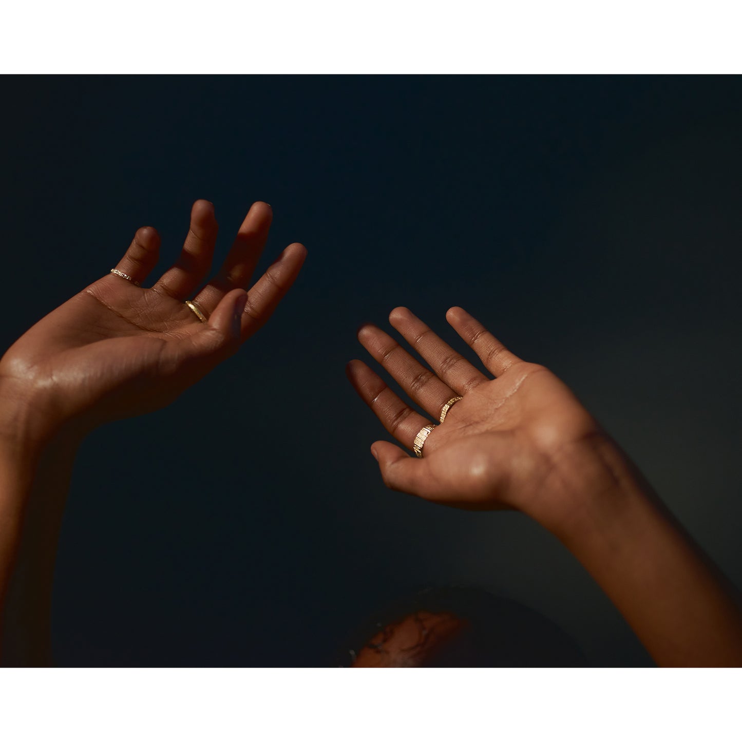 Picture of models hands in the air with handmade textured rings