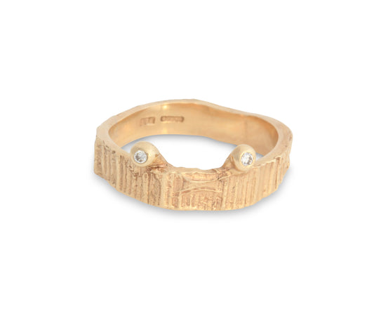 Yellow gold textured wedding ring with diamond eyes like a crab.