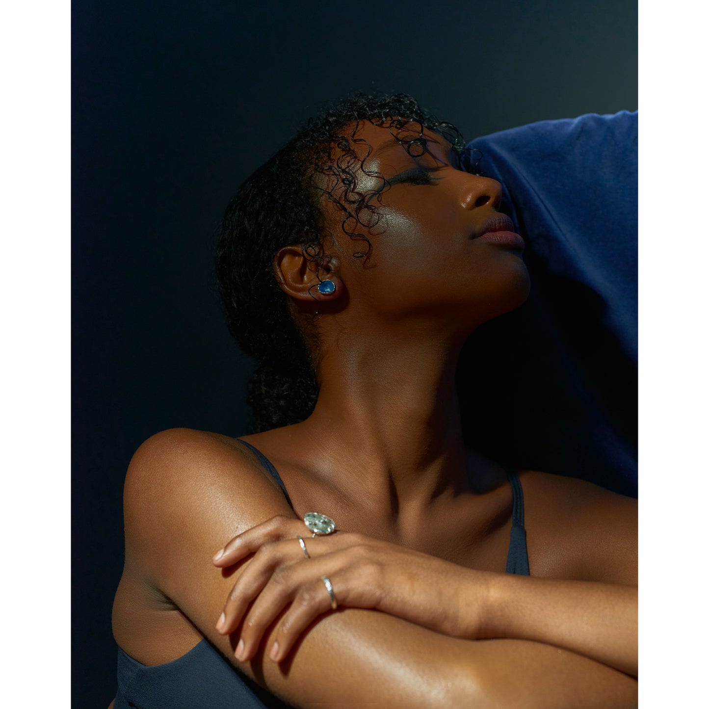 Picture of a model wearing blue enamelled earrings and also some earrings handmade by Bristol based jeweller Eily O Connell.