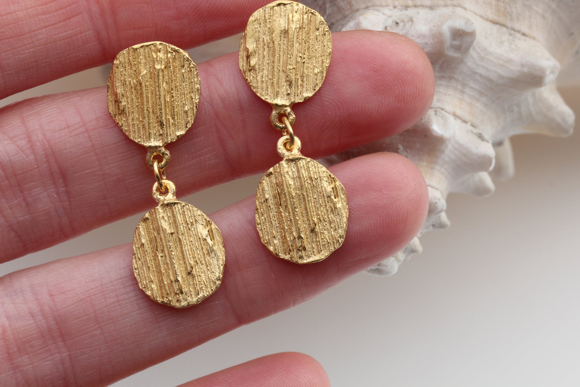 Picture of the bark textured drop earrings being held so you can see size.