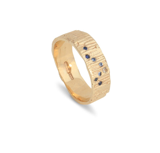 Wedding Ring with blue sapphires in the shape of a wave on a white background. Perfect surfer girl ring