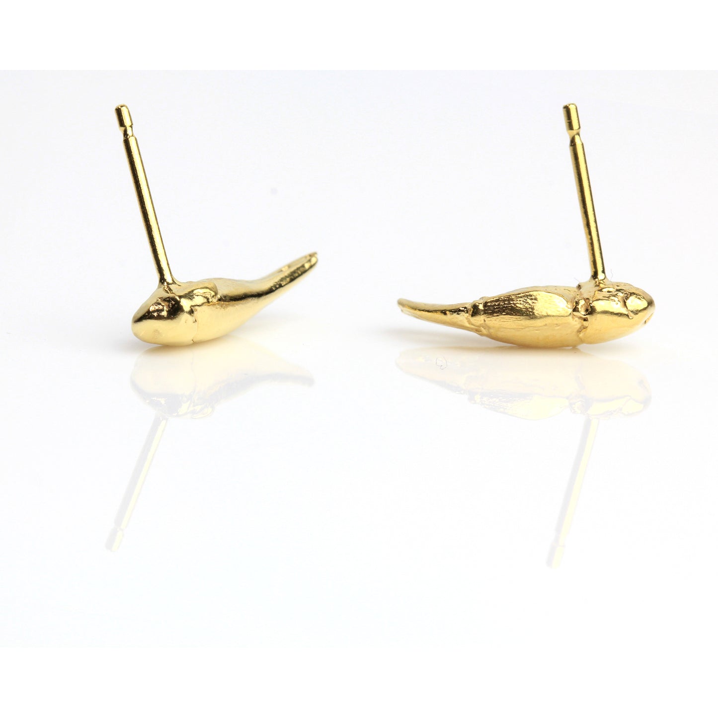 A pair of gold stud earrings cast from tiny crab claws into gold showing back studs