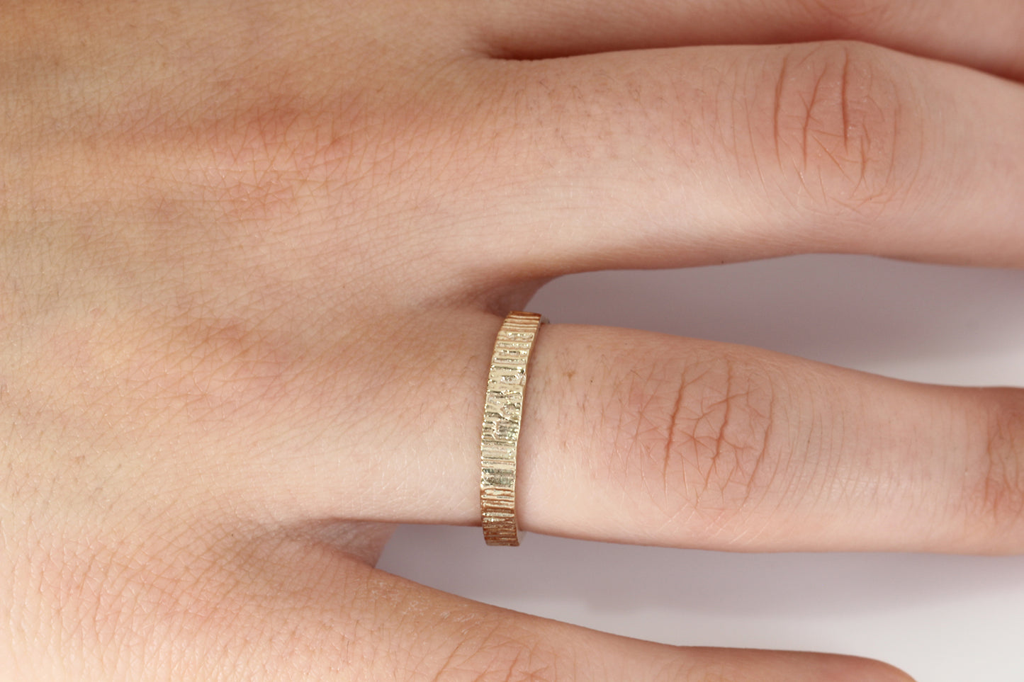 Alternative wedding band in gold with bark texture.