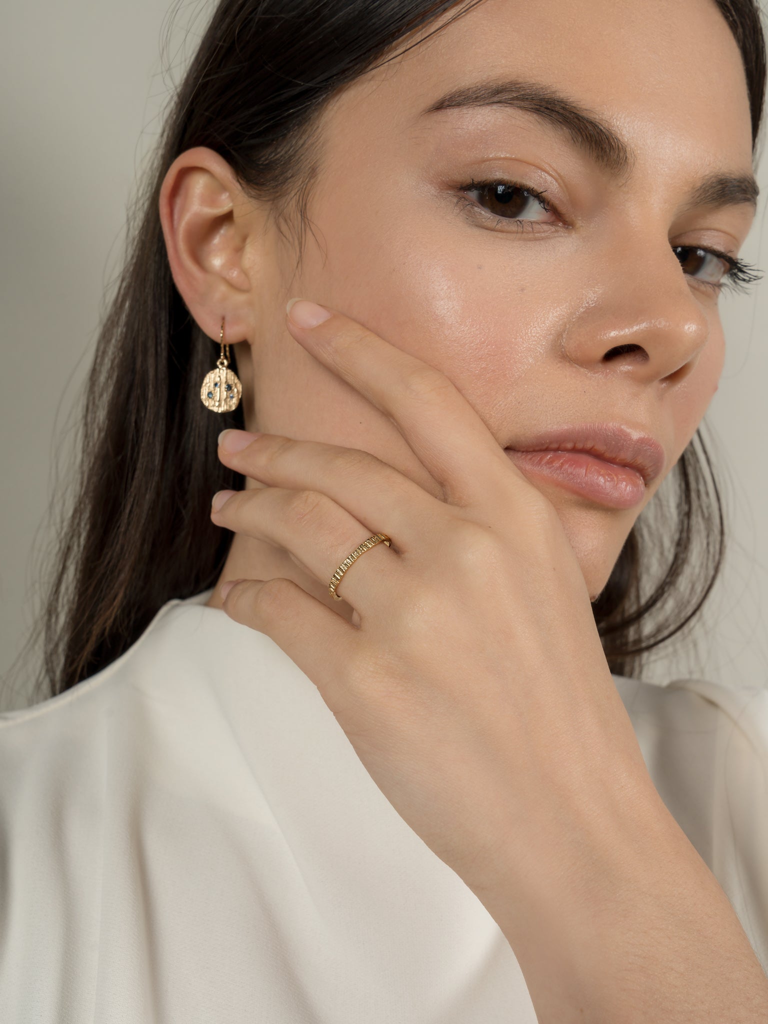 Model wearing earrings with sapphires and also wearing a ring handmade by eily o connell