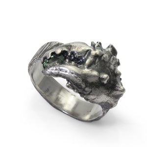 A blackened silver ring shaped like a crab claw holding a green sapphire gemstone. Perfect for a mans Christmas present. A nice piece of jewellery for a fashion conscious man. 