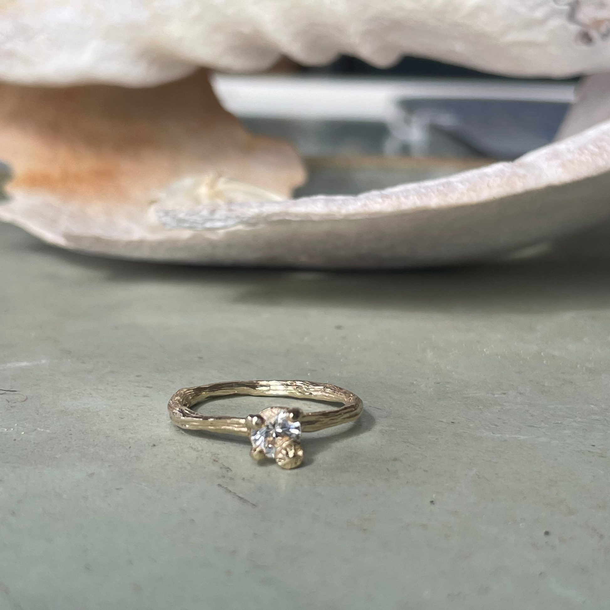 gold organic textured ring with cast berry on top of a white sapphire. Nice alternative to a diamond solitaire ring. Perfect alternative engagement ring. 