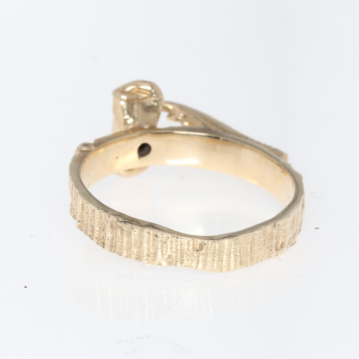 A textured yellow gold ring back view on a plain white background.