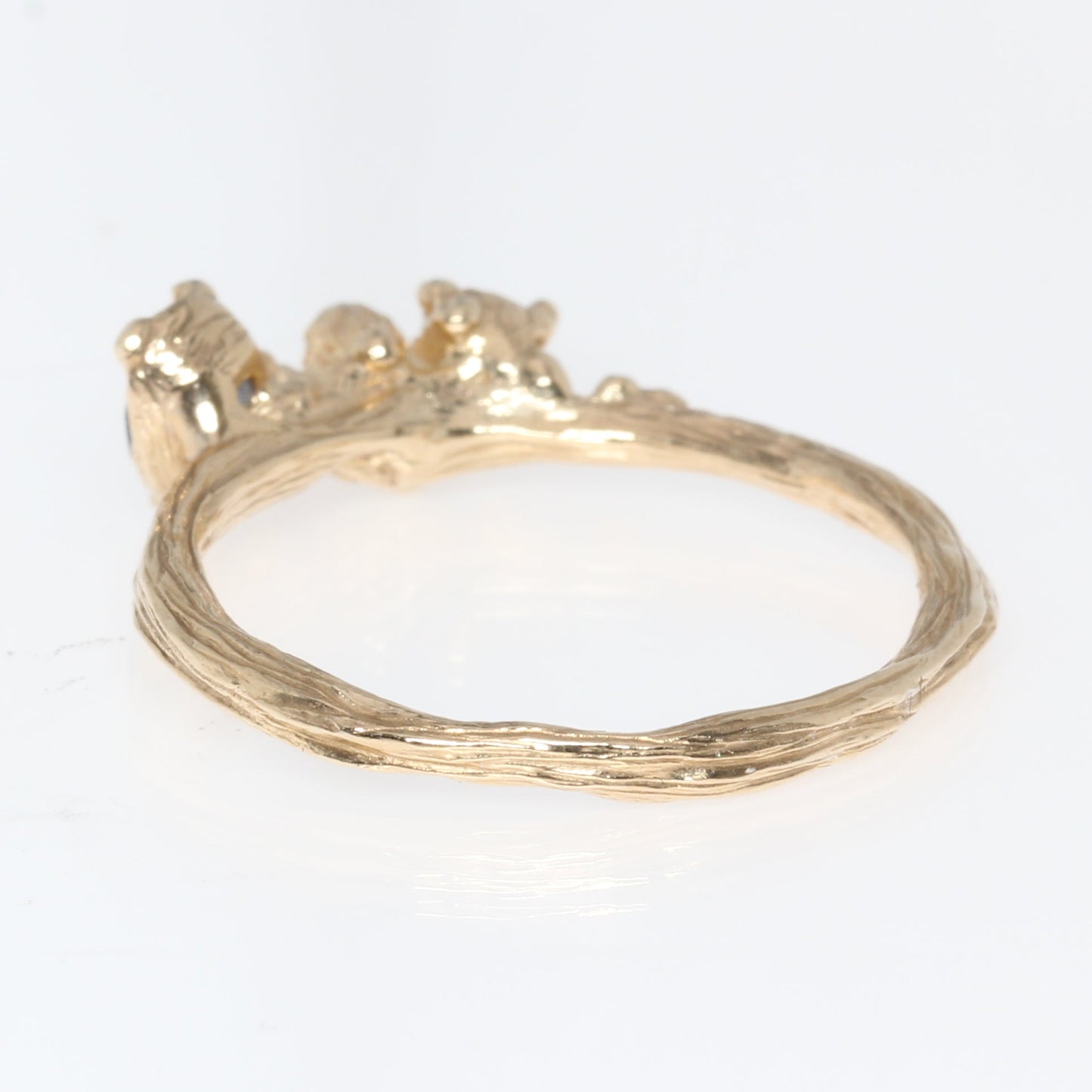 Gold ring back view with a small decorative element on a white background