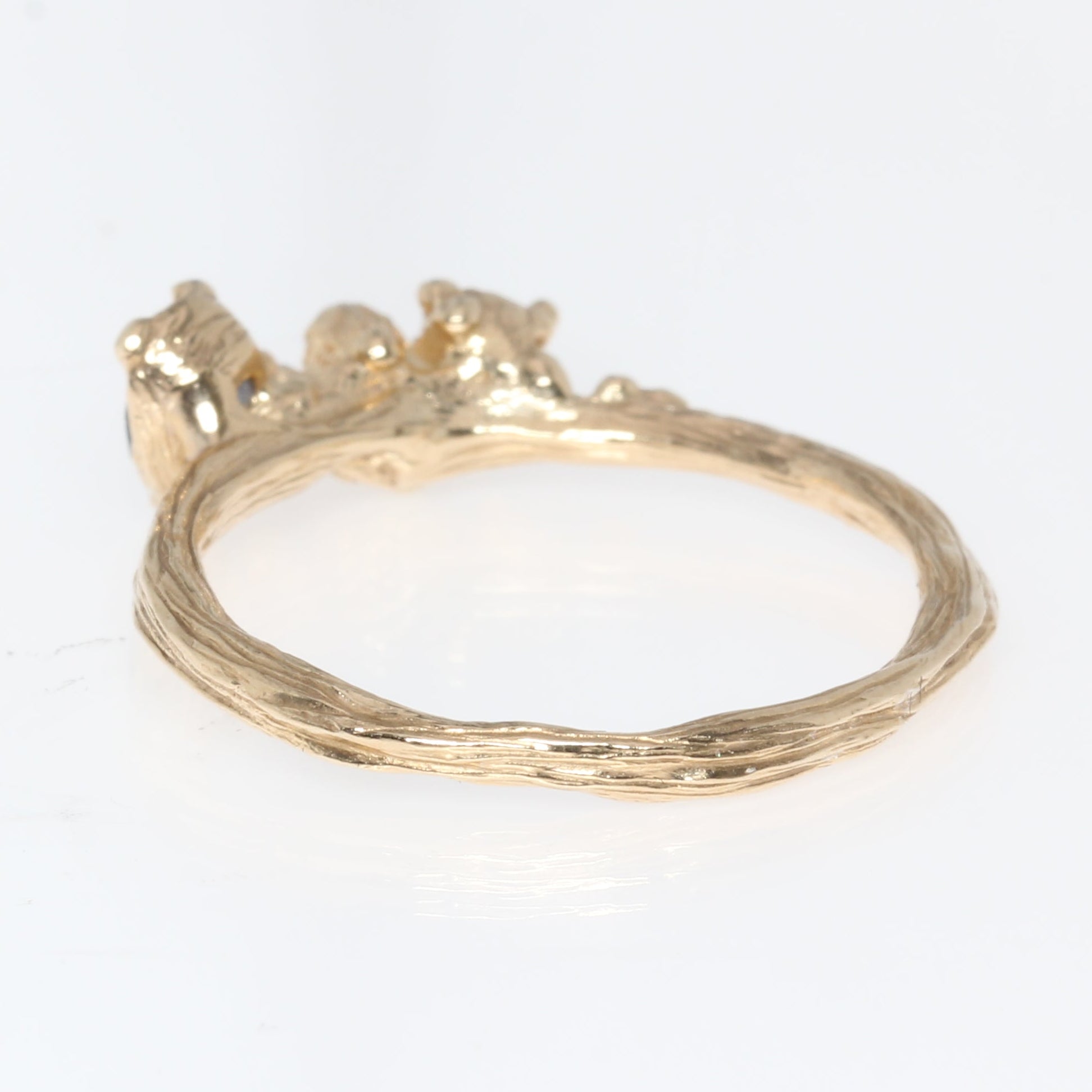 Gold ring back view with a small decorative element on a white background