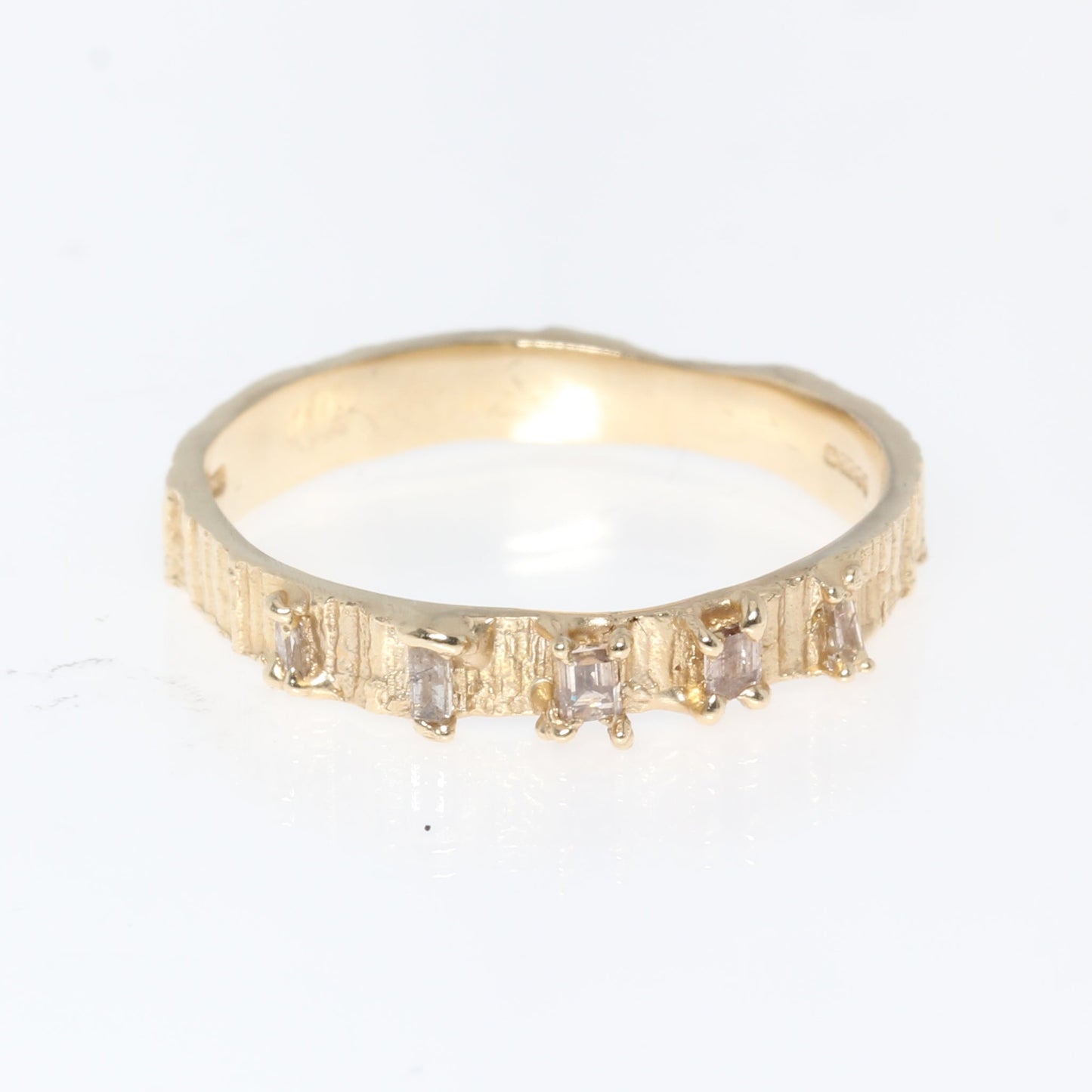 Gold ring with small diamonds on a white background