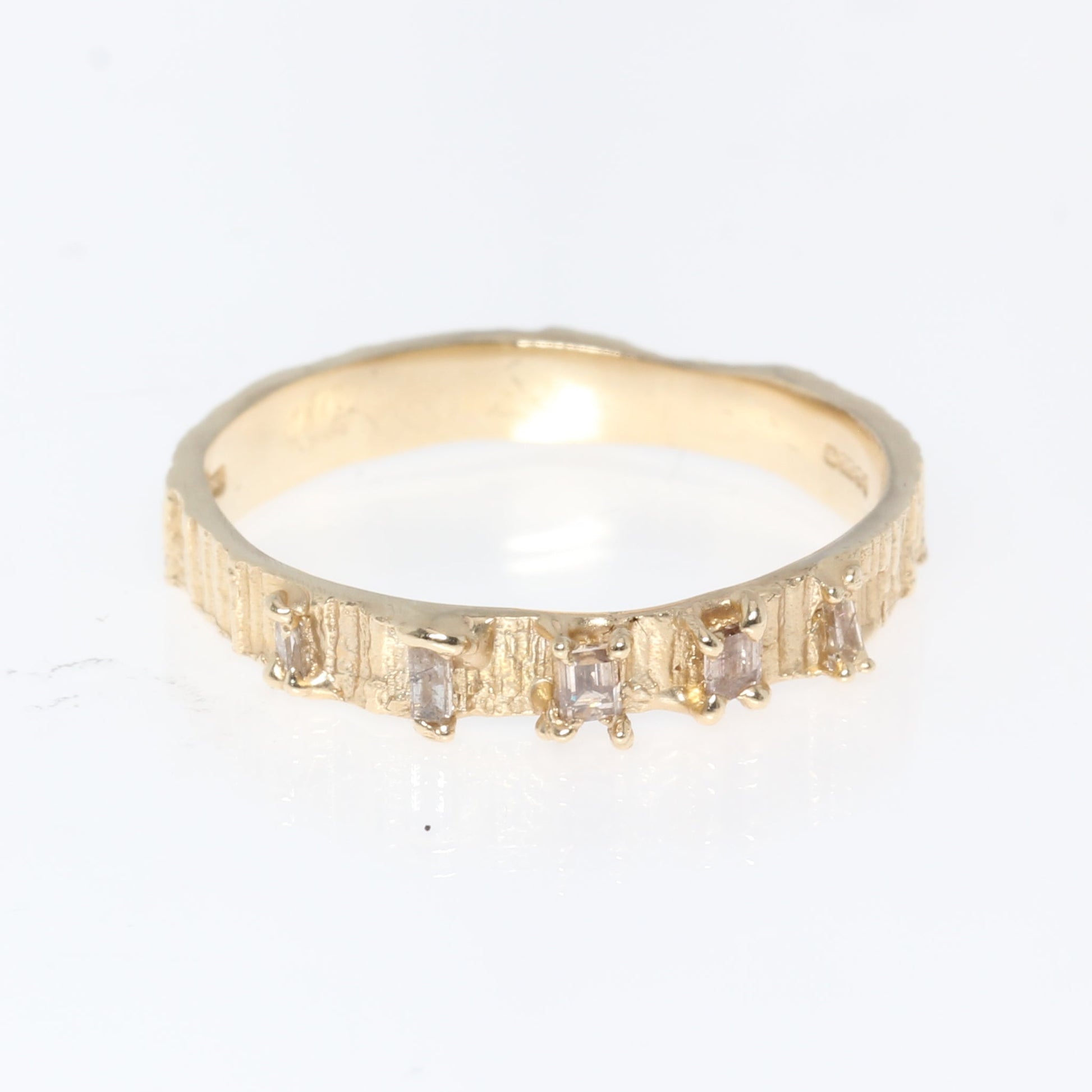 Gold ring with small diamonds on a white background