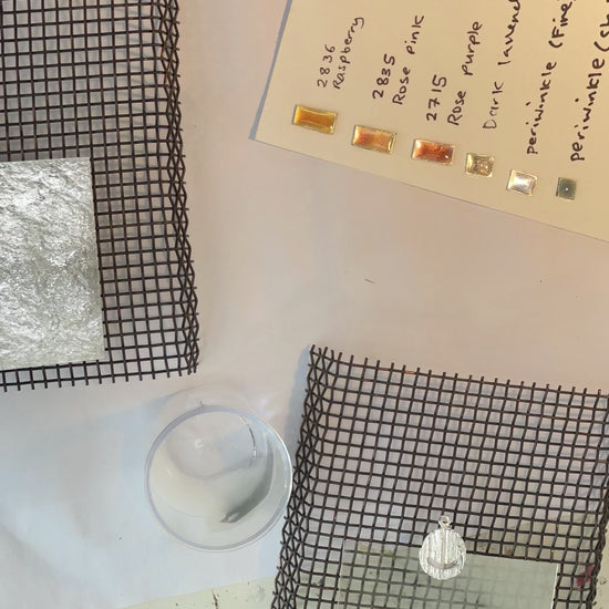 jeweller enamelling pendants with plique a jour enamel technique. 