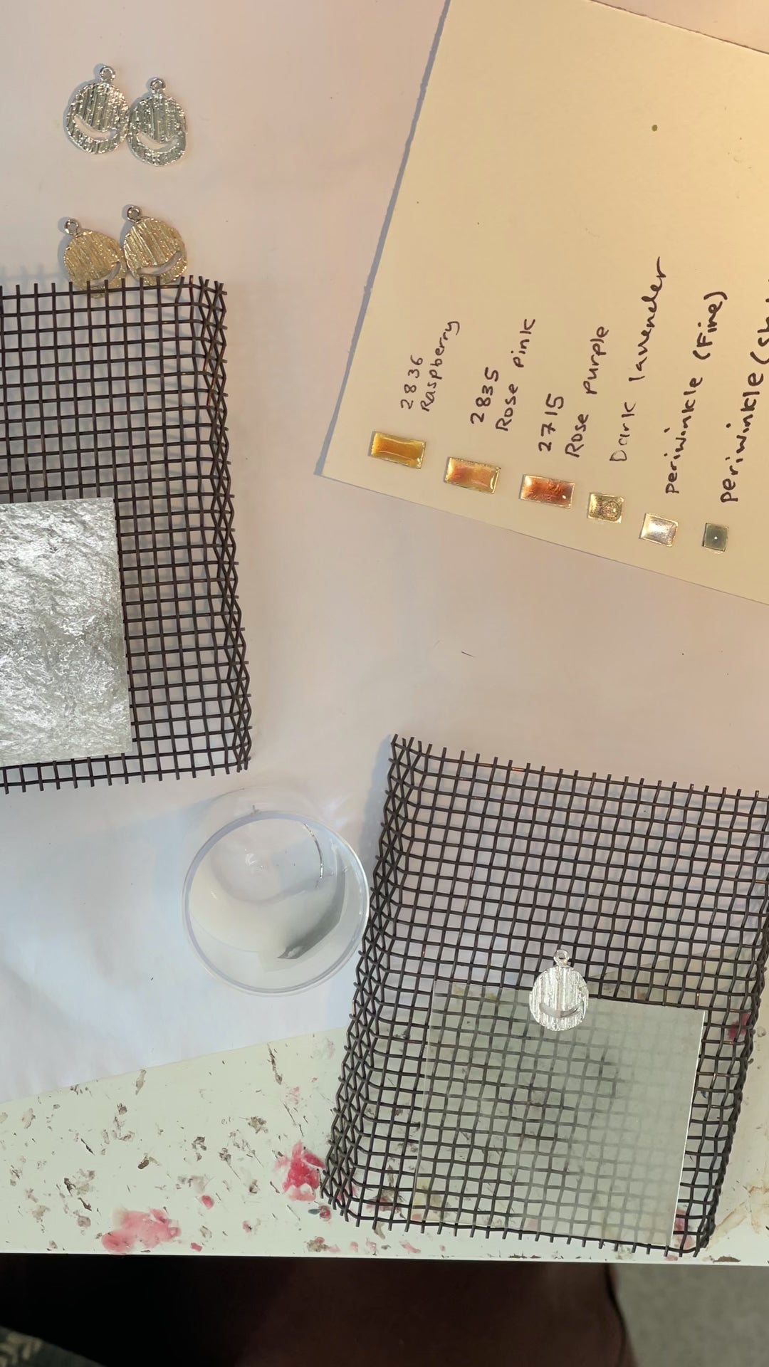 jeweller enamelling pendants with plique a jour enamel technique. 