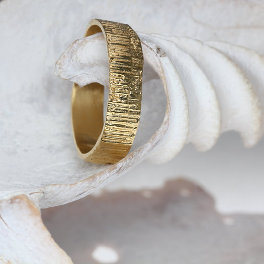 Gold wedding ring on a white shell