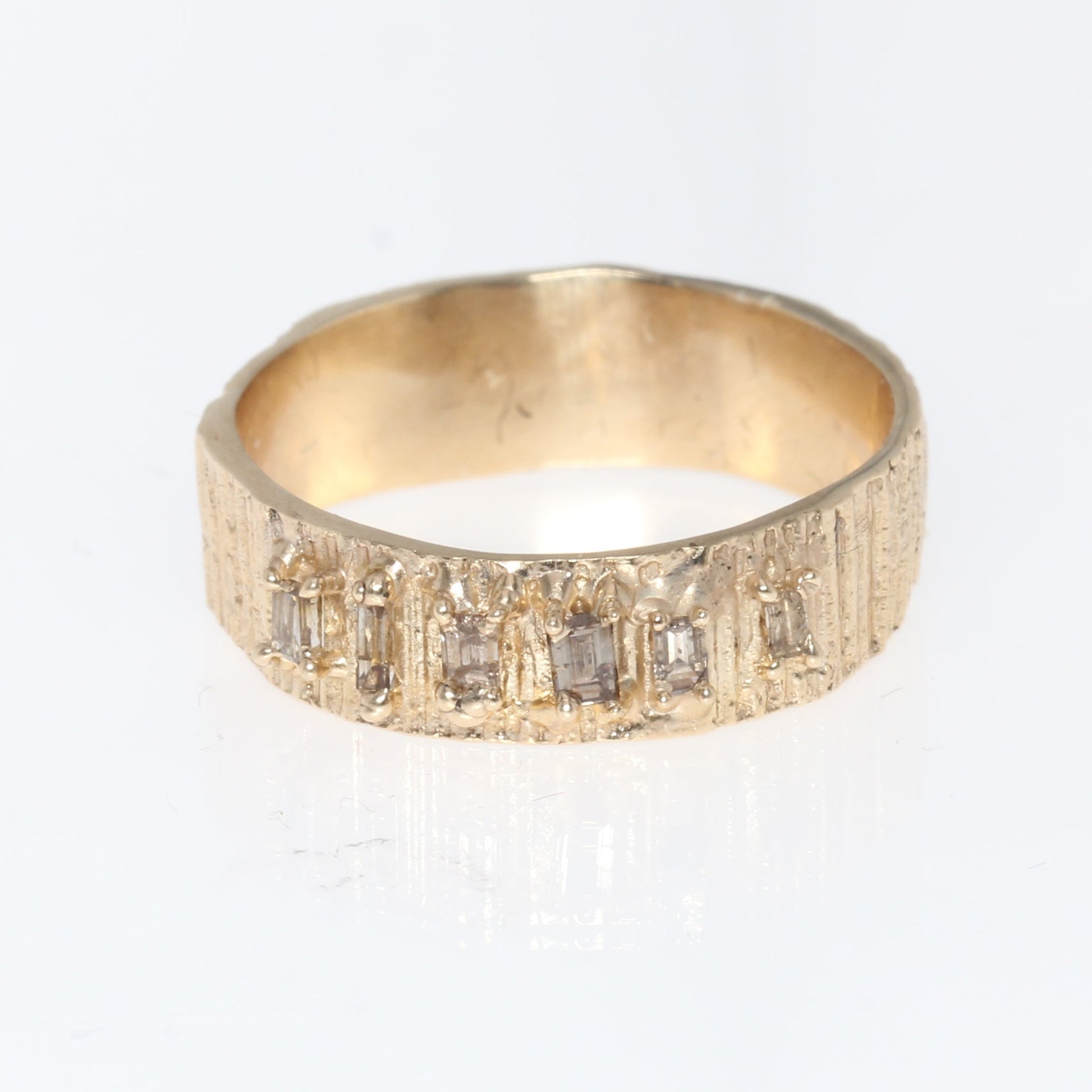 Gold ring with embedded stones on a white background