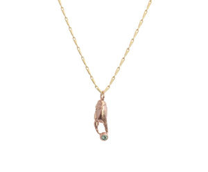 Red gold crab claw on a yellow gold chain holding green tourmaline gemstone which is Fairtrade. 